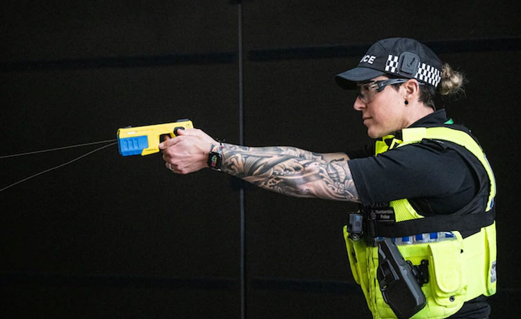 Un agent de police utilise un pistolet à impulsion électrique.