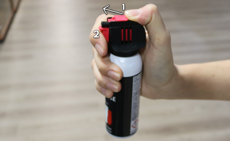 Activation d'une bombe lacrymogène avec languette de sécurité.
