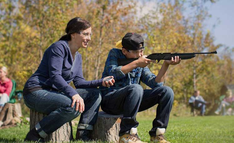 Un jeune et une adulte participent à une séance de tir en plein air.