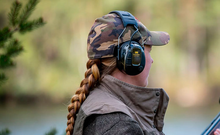 Femme portant un casque anti-bruit pour tirer en extérieur